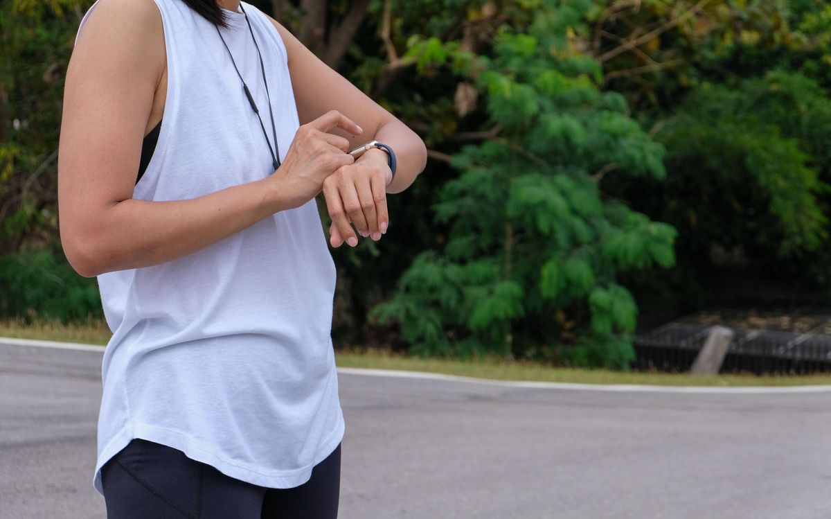 A sporty woman looks at her smartwatch