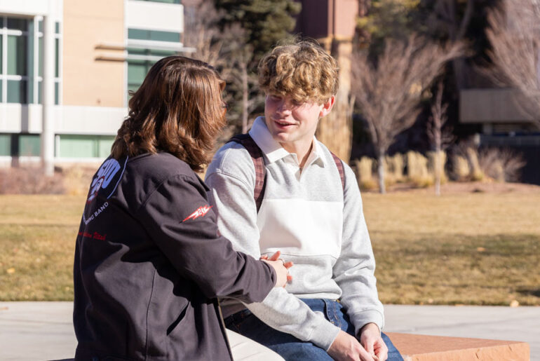 Two students sit outside at Southern Utah University