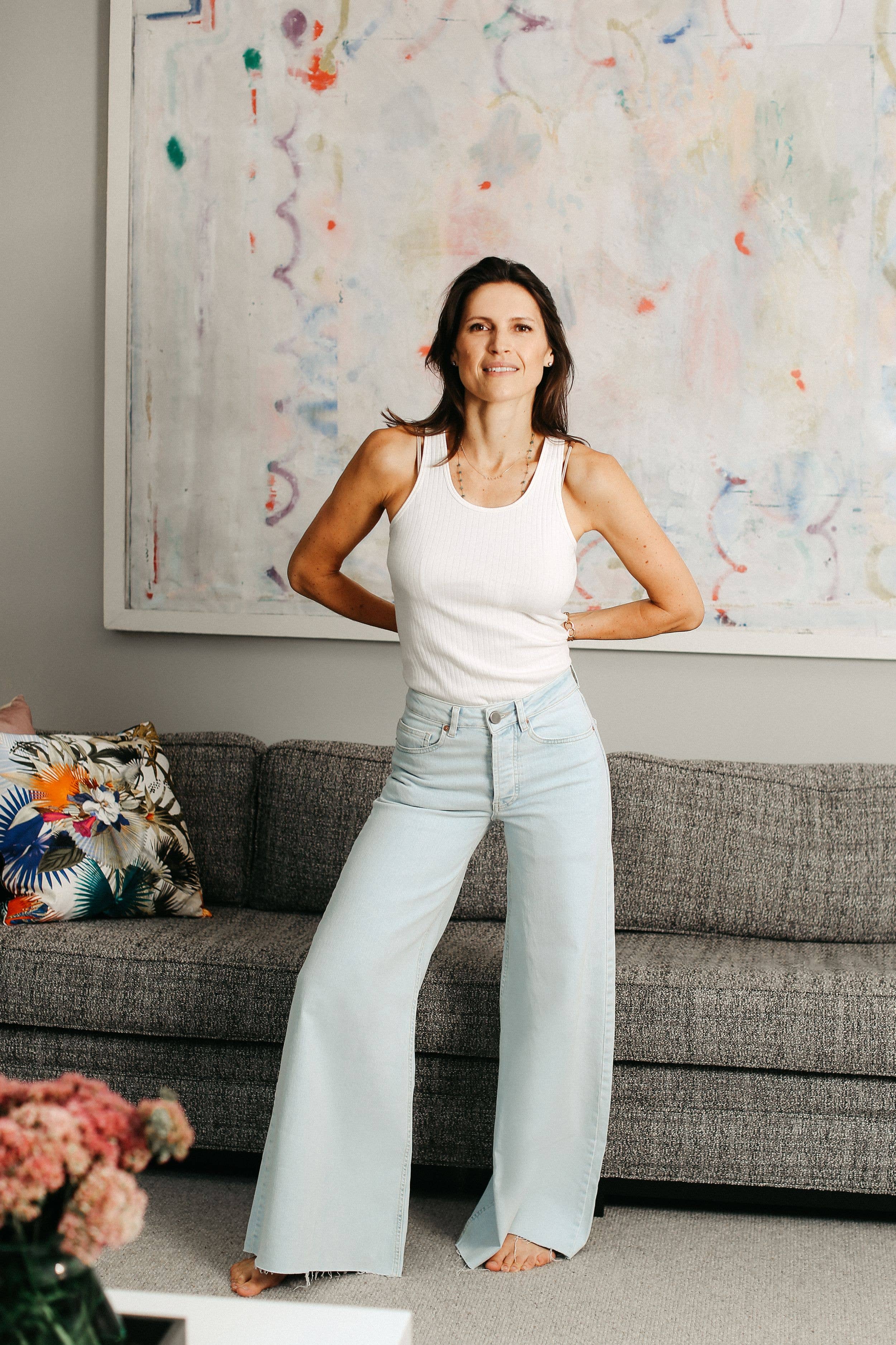woman in jeans and a white top posing at home 