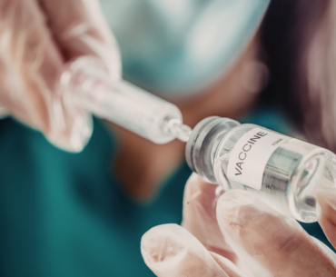 doctor drawing up a dose from a vaccine vial