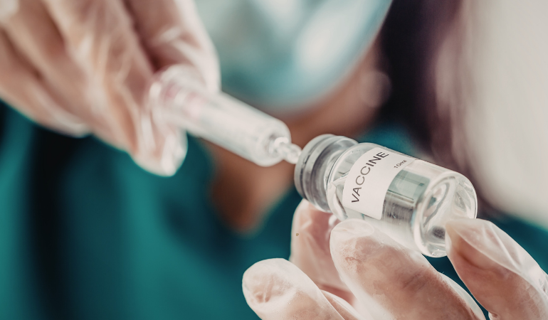 doctor drawing up a dose from a vaccine vial