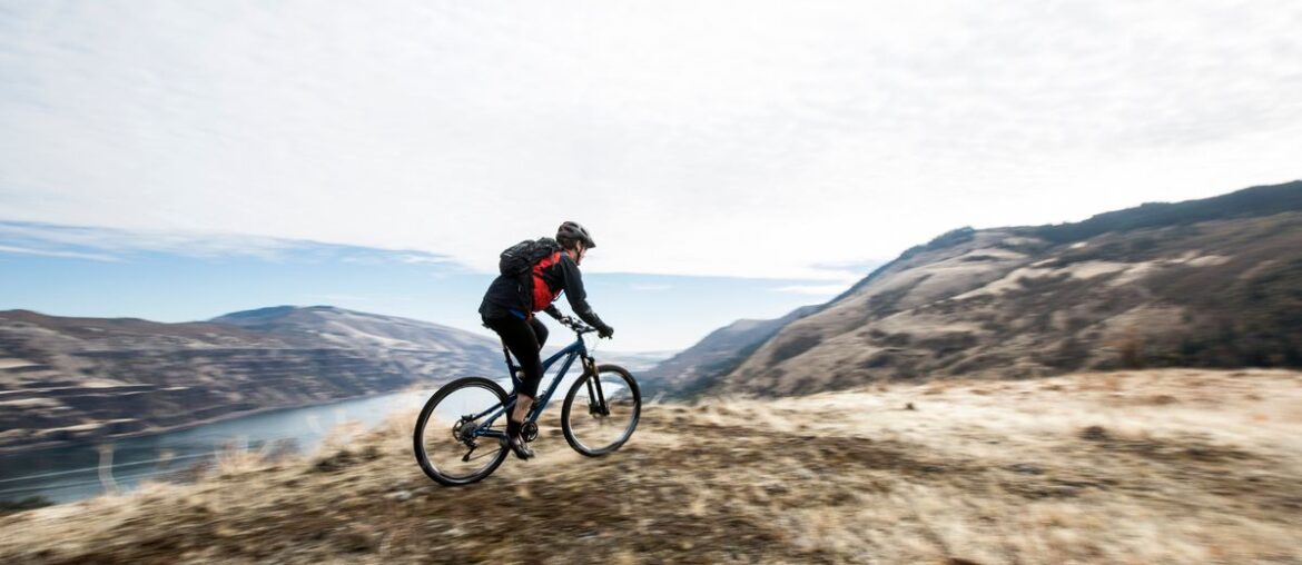 Stock image - A man mountain biking along a scenic overlook.