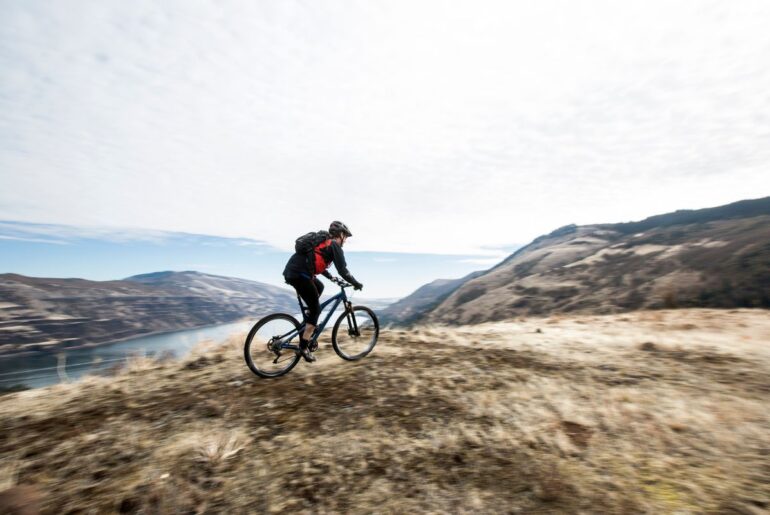 Stock image - A man mountain biking along a scenic overlook.