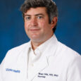 uci health neurologist dr brian hitt wearing a white coat in front of a blue studio background