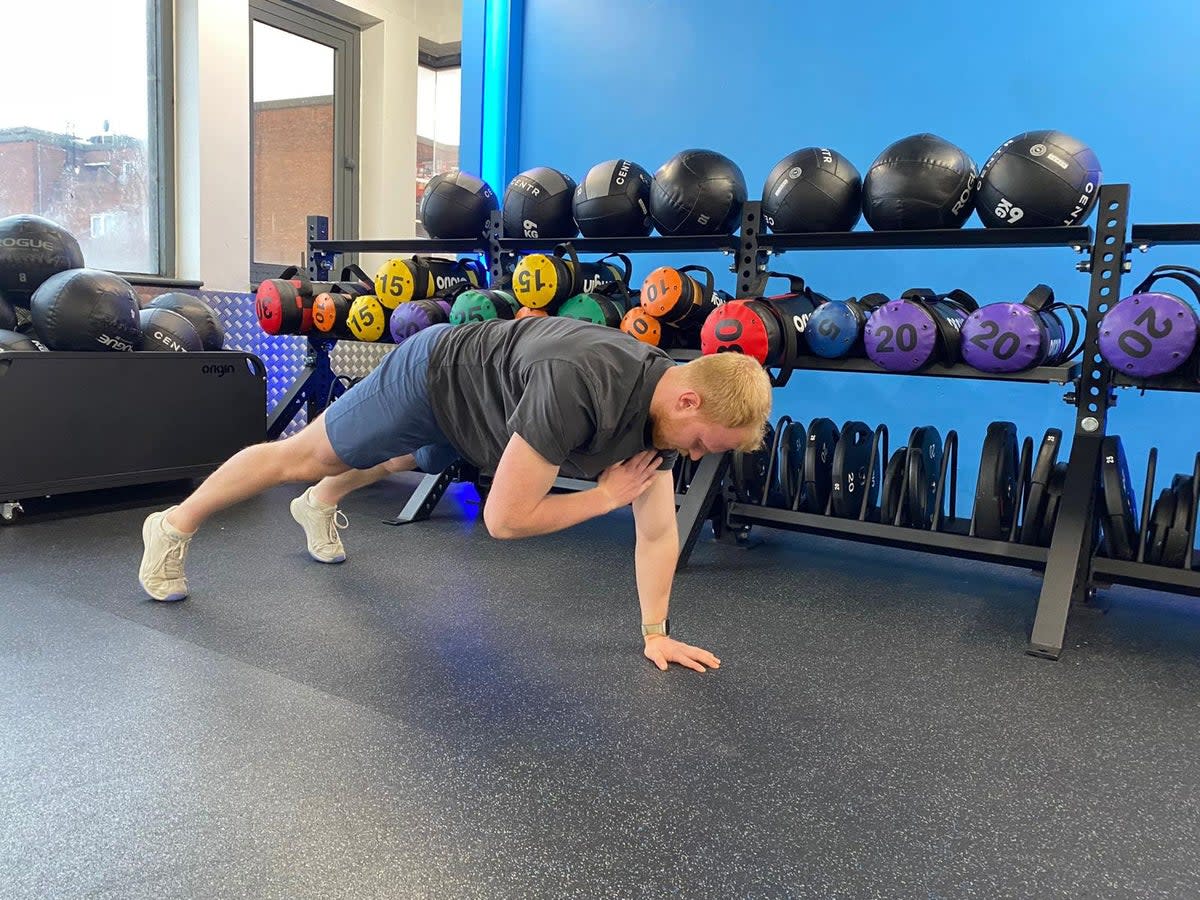 The Independent’s fitness writer Harry Bullmore performing a plank shoulder tap at The Gym Group, Wood Green The Mall (The Gym Group)