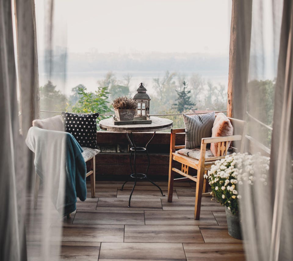 Tiny terrace with bistro table and flowers in planter.
