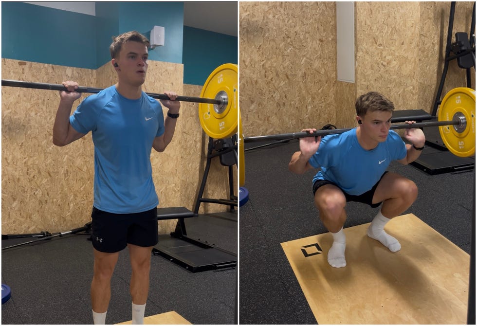 person performing a barbell squat in a gym