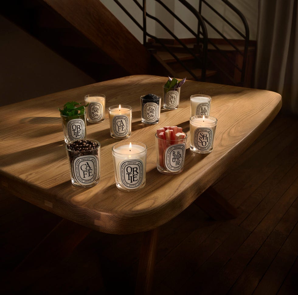 Collection of scented candles on a wooden table.