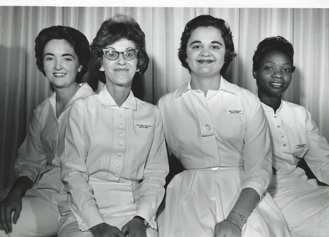 Four women in white uniforms