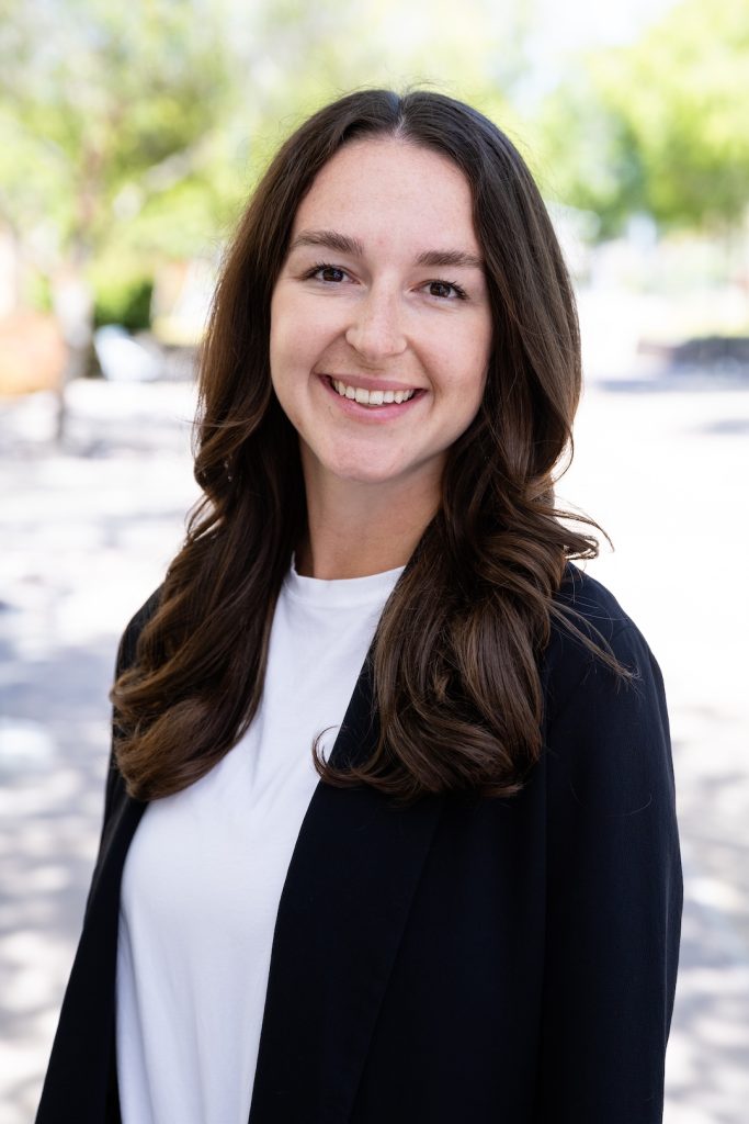 Portrait photo of Dr. Stacey. She is standing outside and smiling at the camera