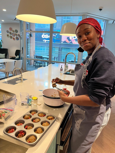 Brianna Guerrier standing in an apron and red headscarf next to a plate of cookies at the Ronald McDonald House