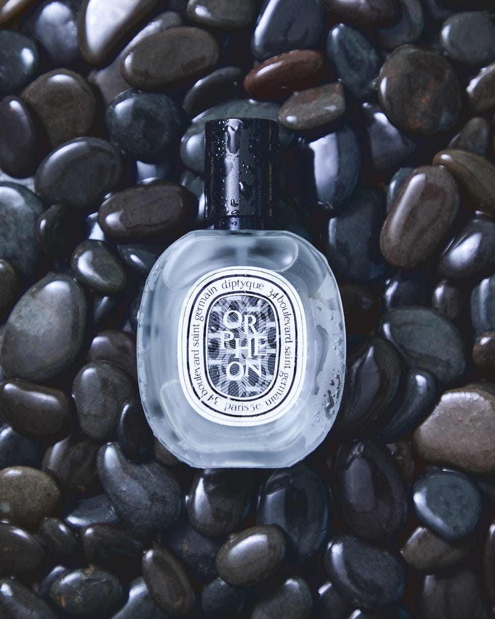 Fragrance bottle resting on a bed of pebbles