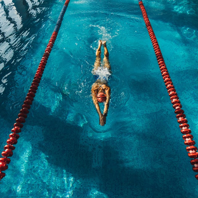 View from above of woman swimming by track in the pool. Sports concept, unrecognizable person.