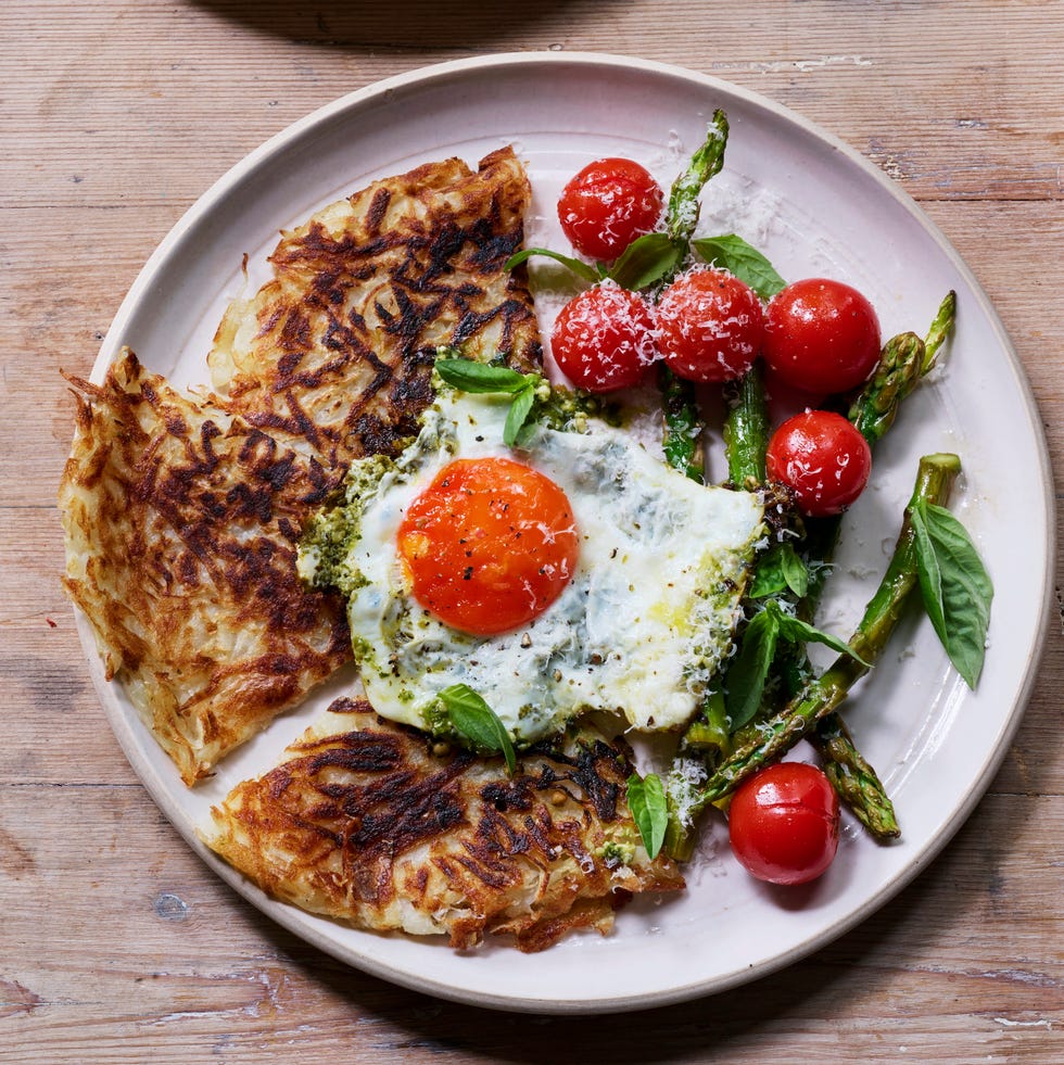 crispy potato rosti topped with fried egg and pesto served on plate