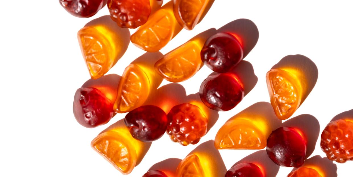 neatly aligned citrus and berry gummies form a dynamic diagonal across bright white selective focus, vitamins and healthy snack for kids promote healthy food, nutrition and healthy life