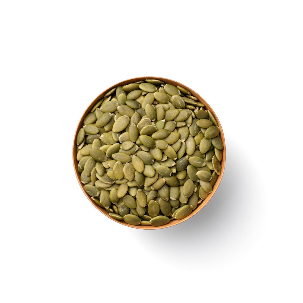 Pumpkin Seeds in Wooden Bowl Isolated on White Background