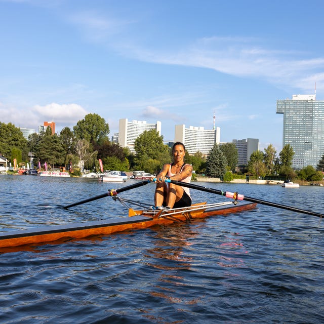 Woman rowing single scull boat, morning workout on the Danube river, Vienna, Austria