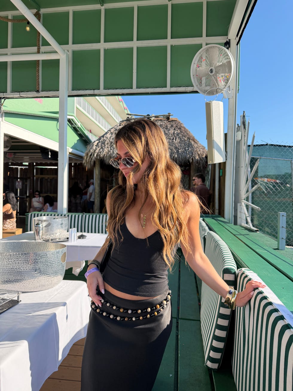 A woman posing in a casual outdoor dining setting.