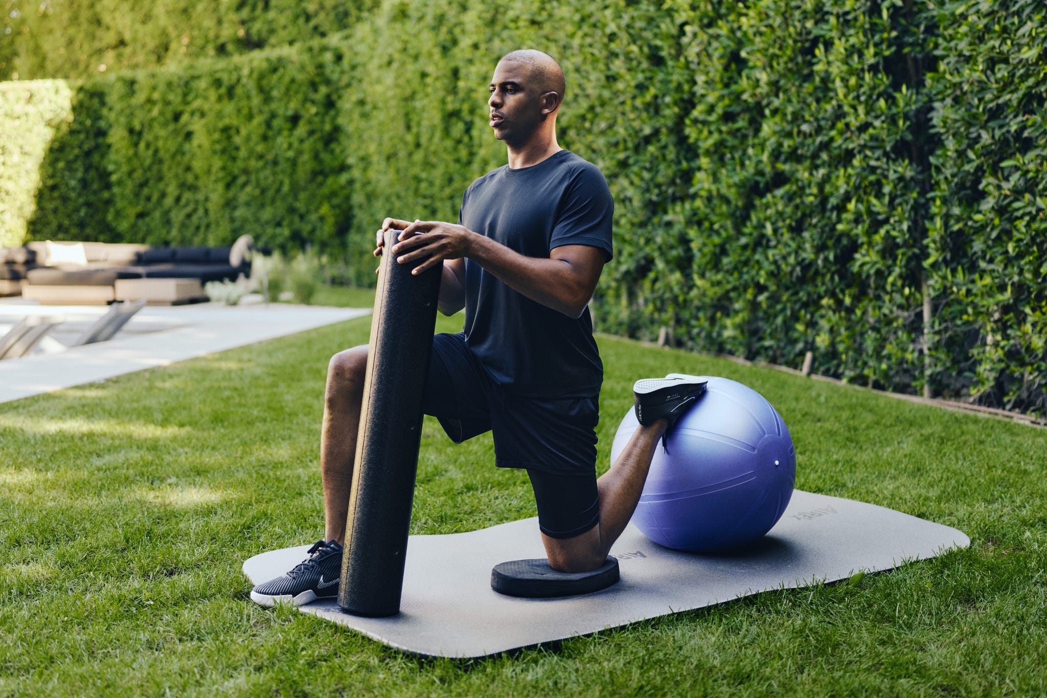 Individual performing an exercise on a mat in an outdoor setting.
