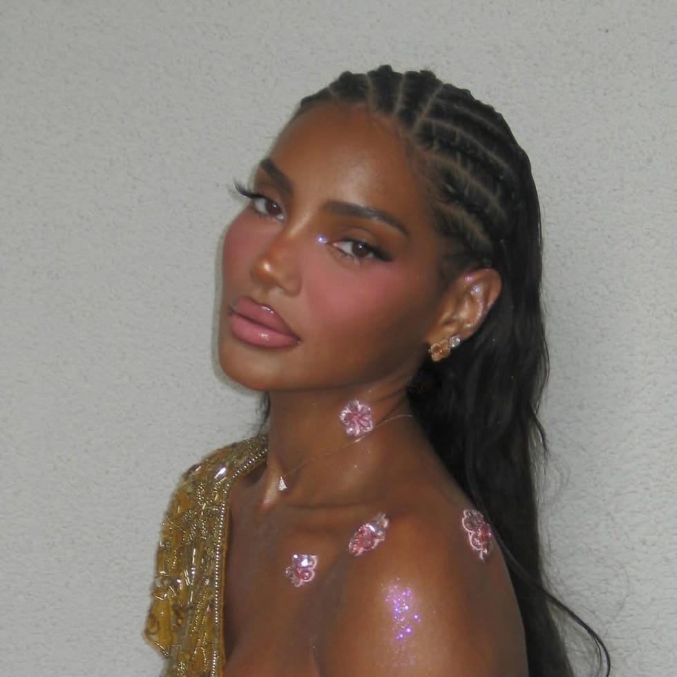 Person adorned with body glitter and floral decorations.