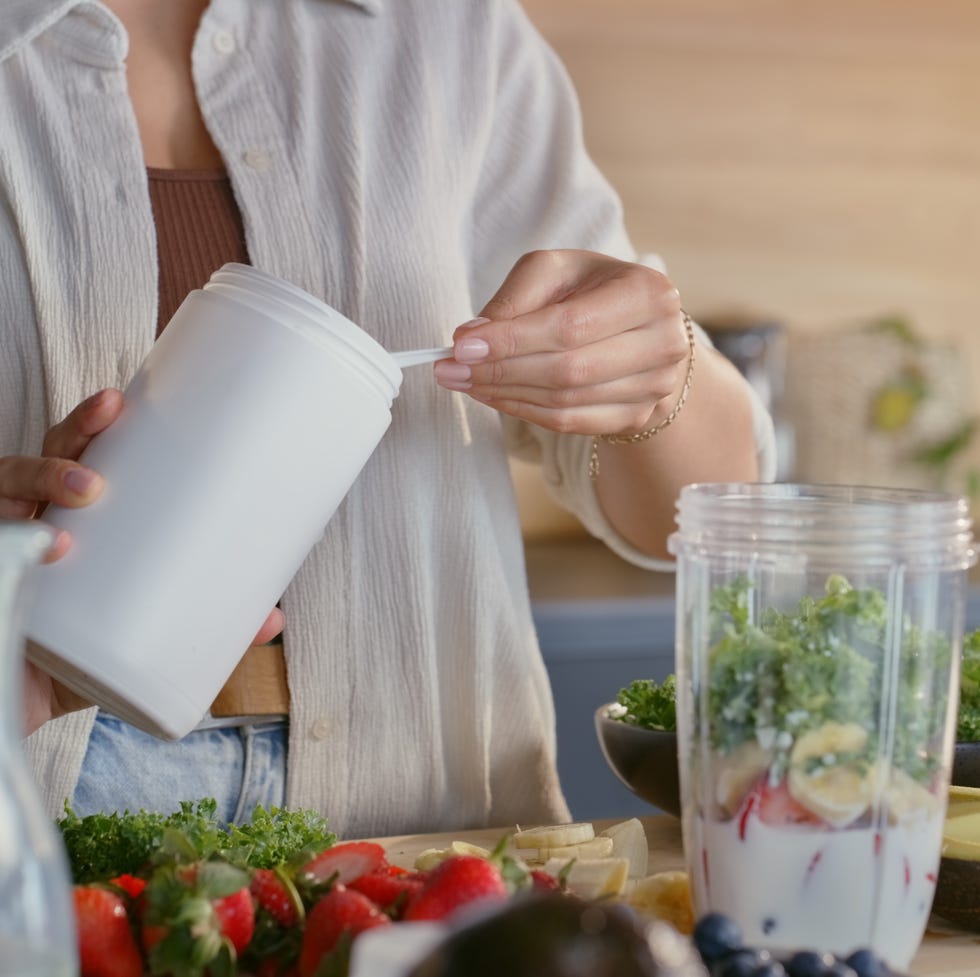 hands, woman and powder for healthy smoothie for collagen drink, protein ingredient and weight loss. person, fruits and blender for nutrition benefits, meal replacement and organic milkshake at house