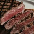 Grilled medium-rare steak sliced on a plate, used as a reference for protein comparison