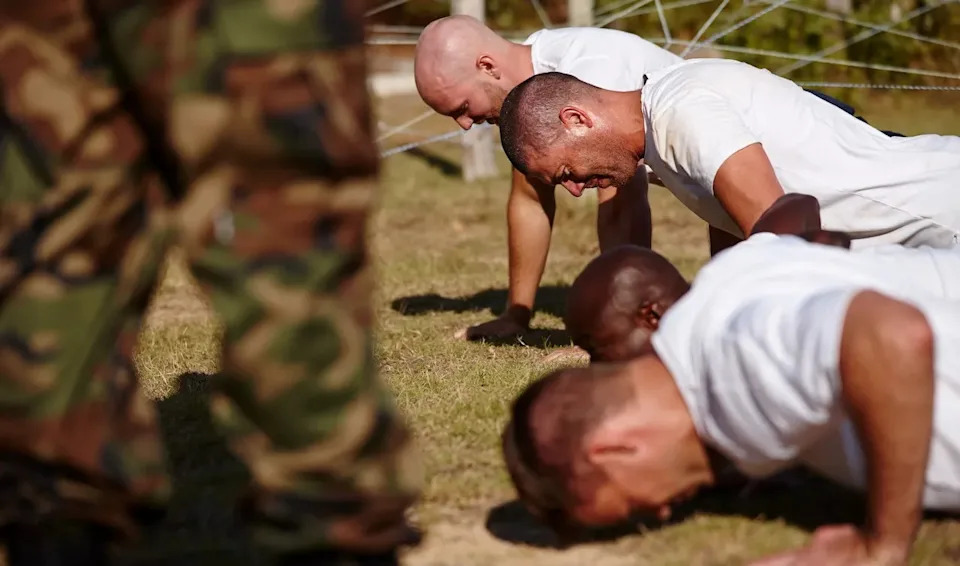A group of men doing push-ups at a military bootcamp