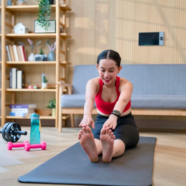 Young adult woman stretching exercising yoga at home