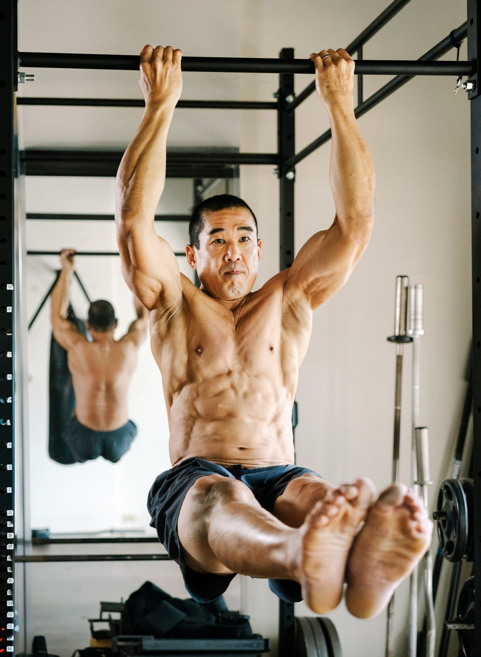 Person performing a hanging exercise in a gym.