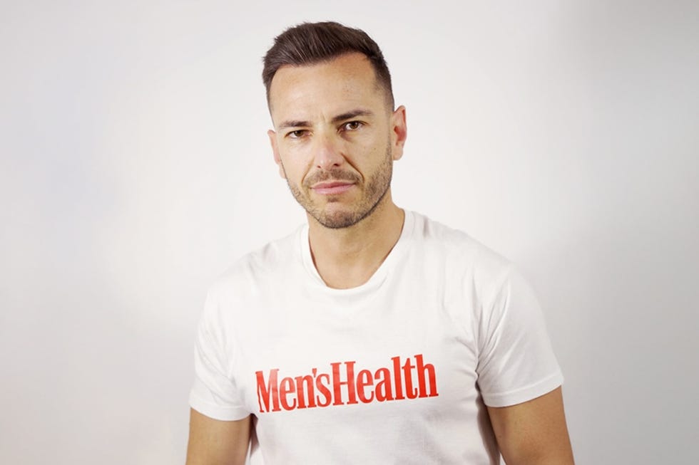 person wearing a white tshirt with mens health printed on it in red