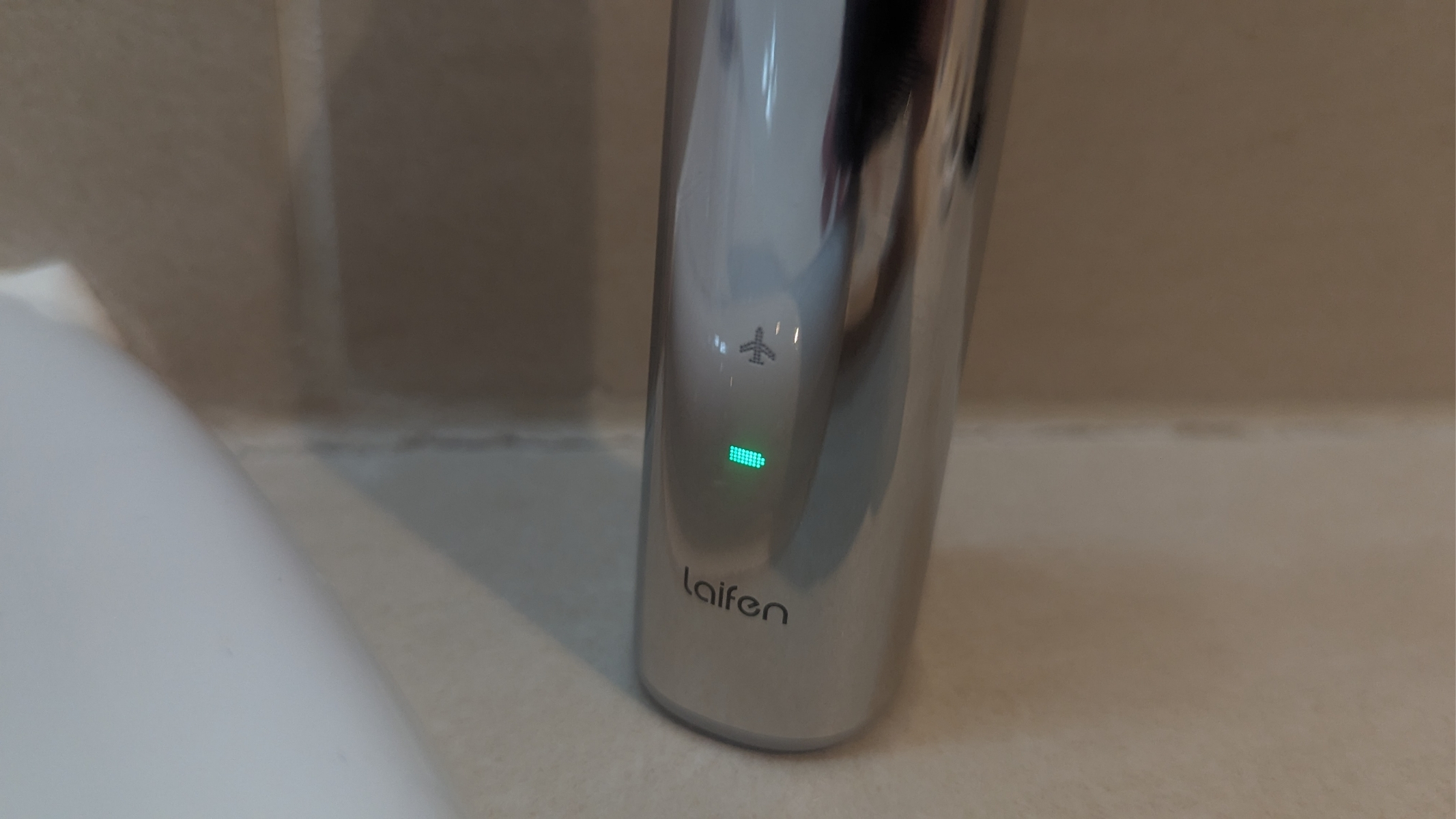 Laifen Wave Pro toothbrush during review, a close up of the travel lock and battery indicator lights.