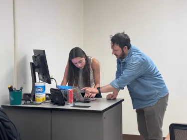 Faculty member assists student with presentation