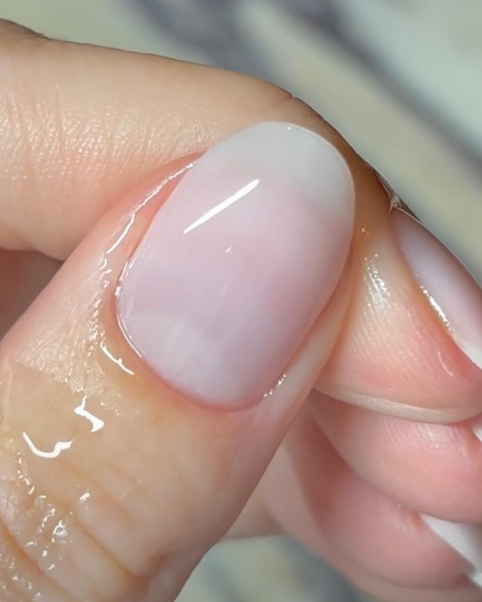 A close-up of a sheer milky manicure