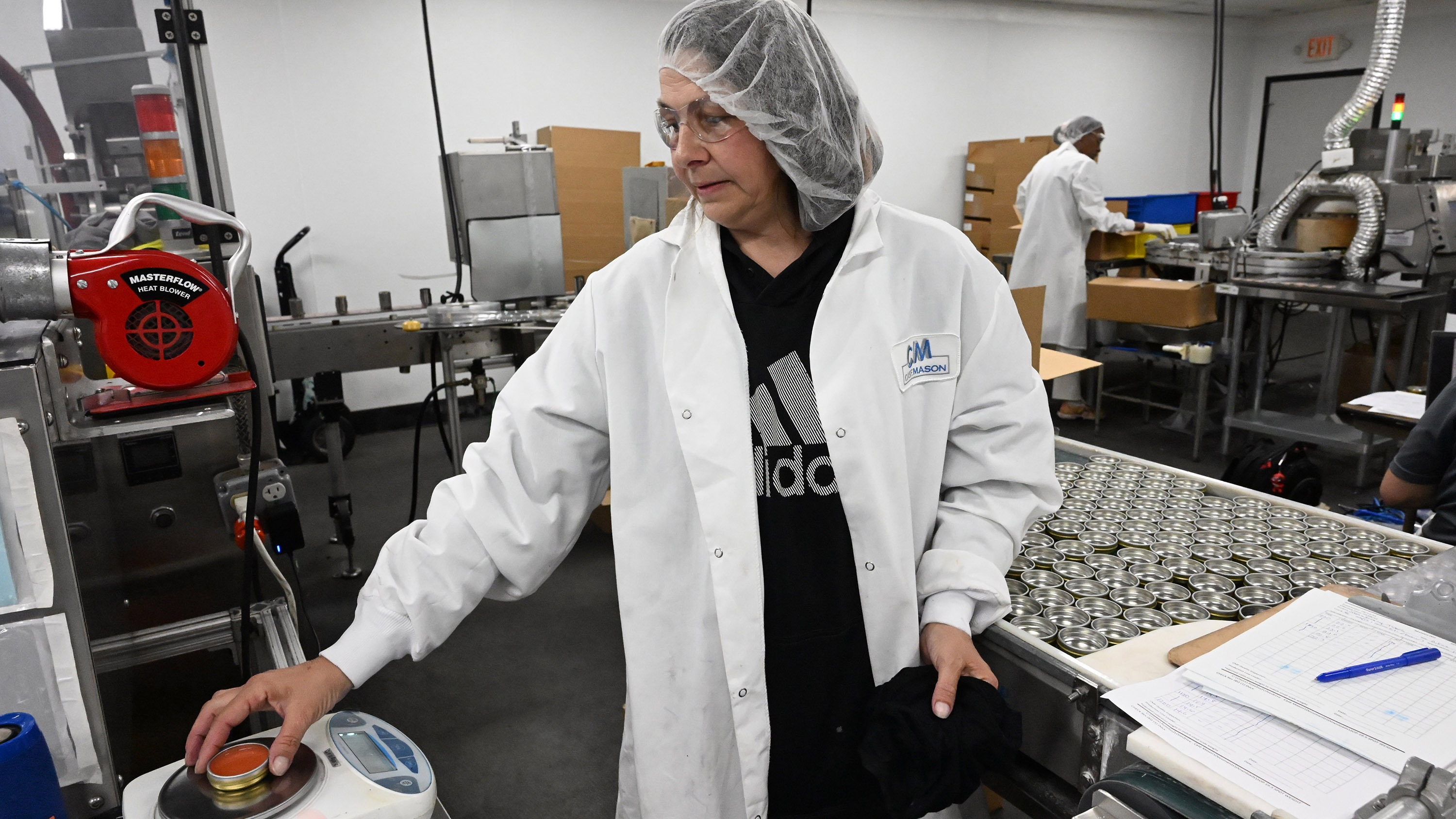 Line lead Dawn Mangan measures the weight of a tin...