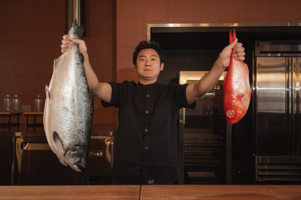 Chef Steven Lee holds two whole fish inside Wellness Counter, the new Boulder restaurant from the team behind Denver's Wellness Sushi, ahead of its May 7 opening at 1117 Pearl St. (John Zamora Photography/Courtesy photo)