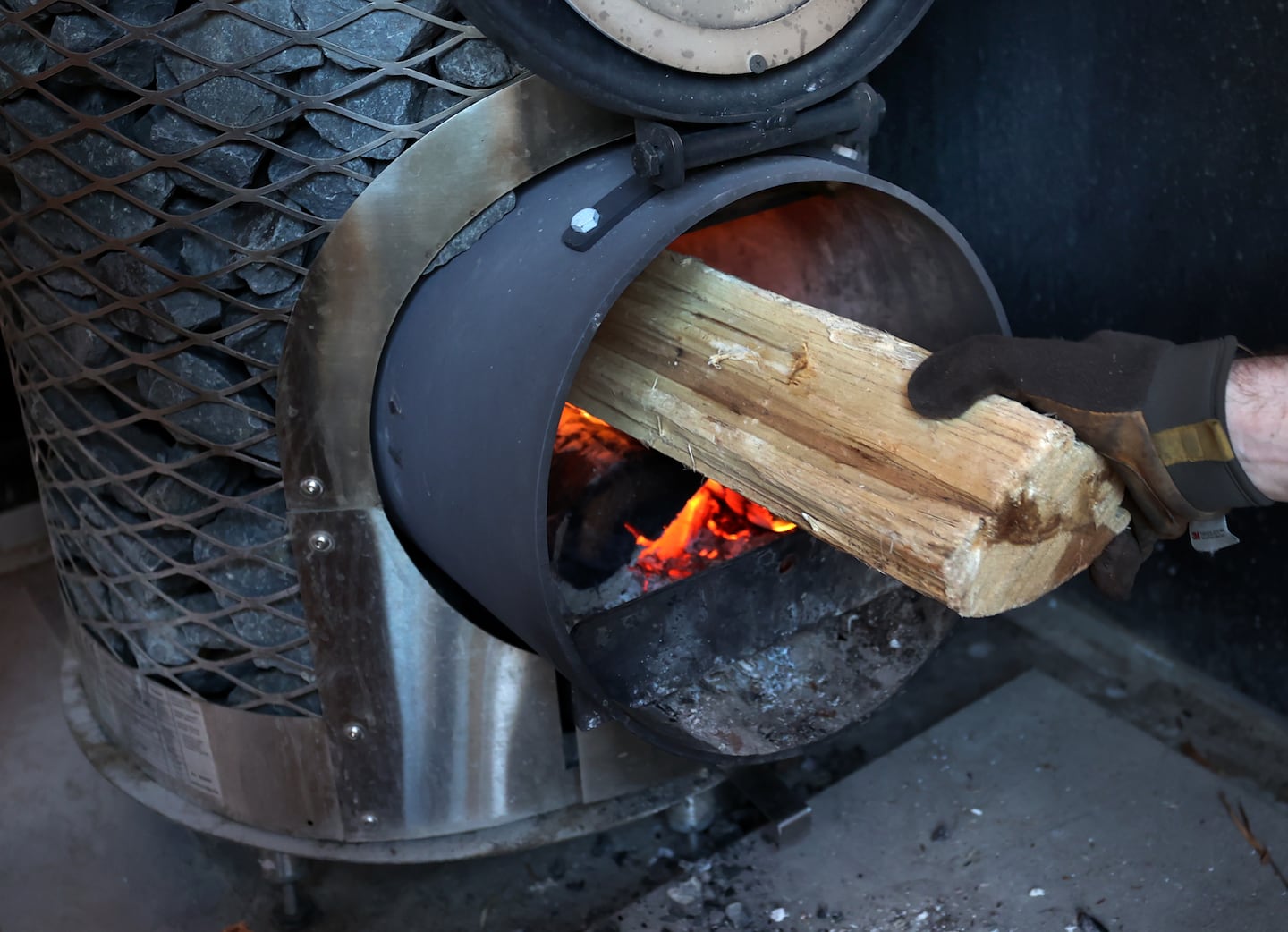 A log was placed in the stove to heat rocks in the sauna at MOKI Sauna Village in 2024.