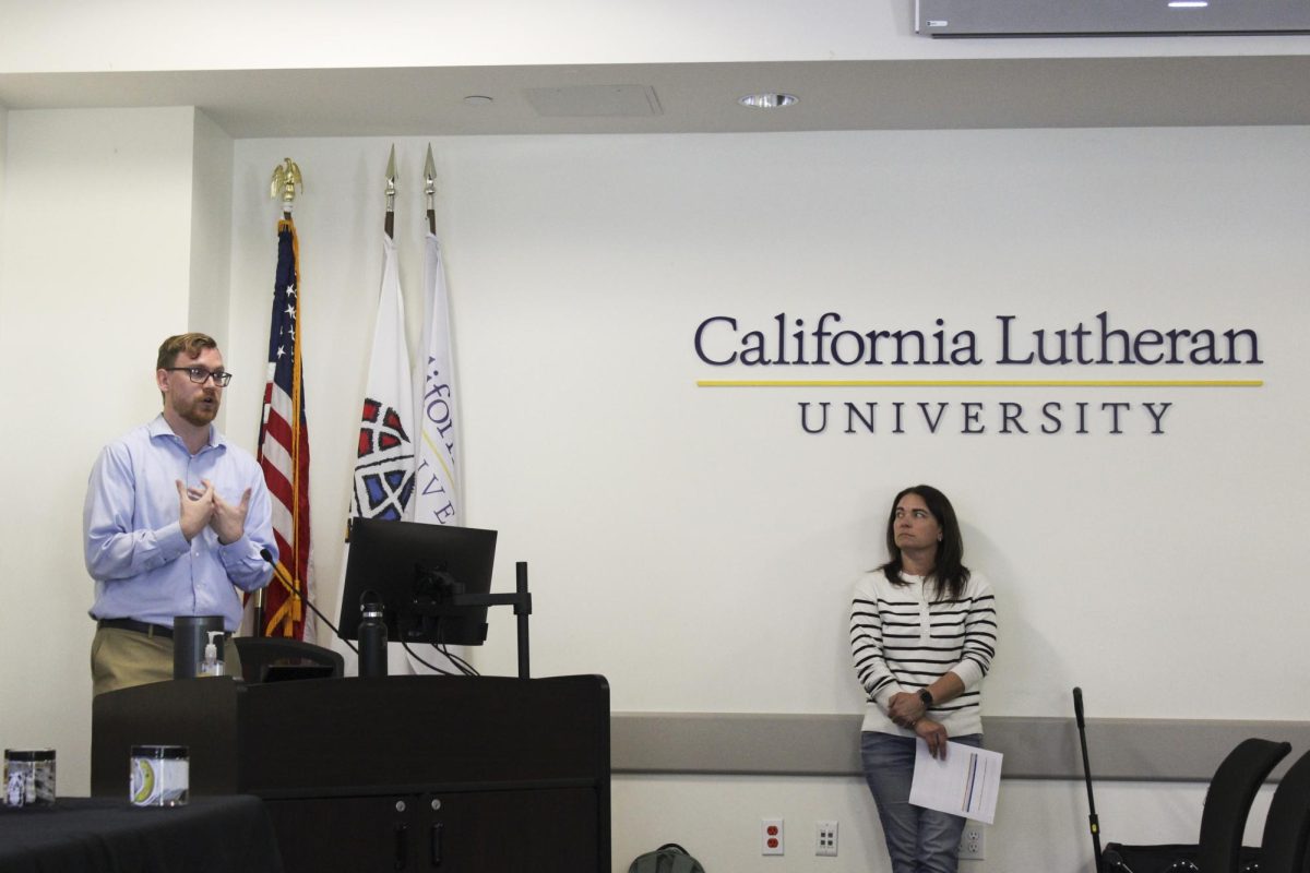 Ricardo Cornejo (left), a CAPS psychologist who holds a doctorate in clinical psychology and serves as the CAPS athletics liaison, presents a slideshow at the workshop alongside Christy Linder (right), a trainee clinician at CAPS.