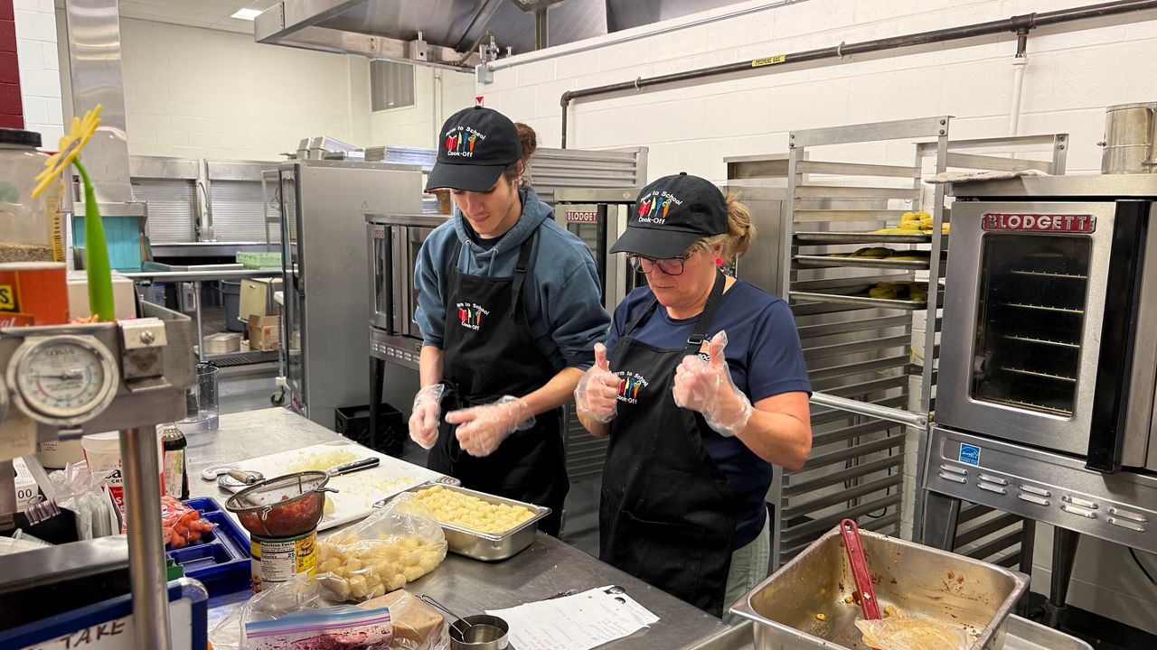 Westbrook School Department student Riley Davis and nutrition staff member Kelly Bourgeios prepare a meal during Wednesday’s competition. (Spectrum News/David Ledford)