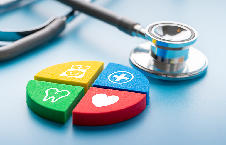 Stethoscope next to colorful health icons representing dental, medical, and heart care on a blue surface.