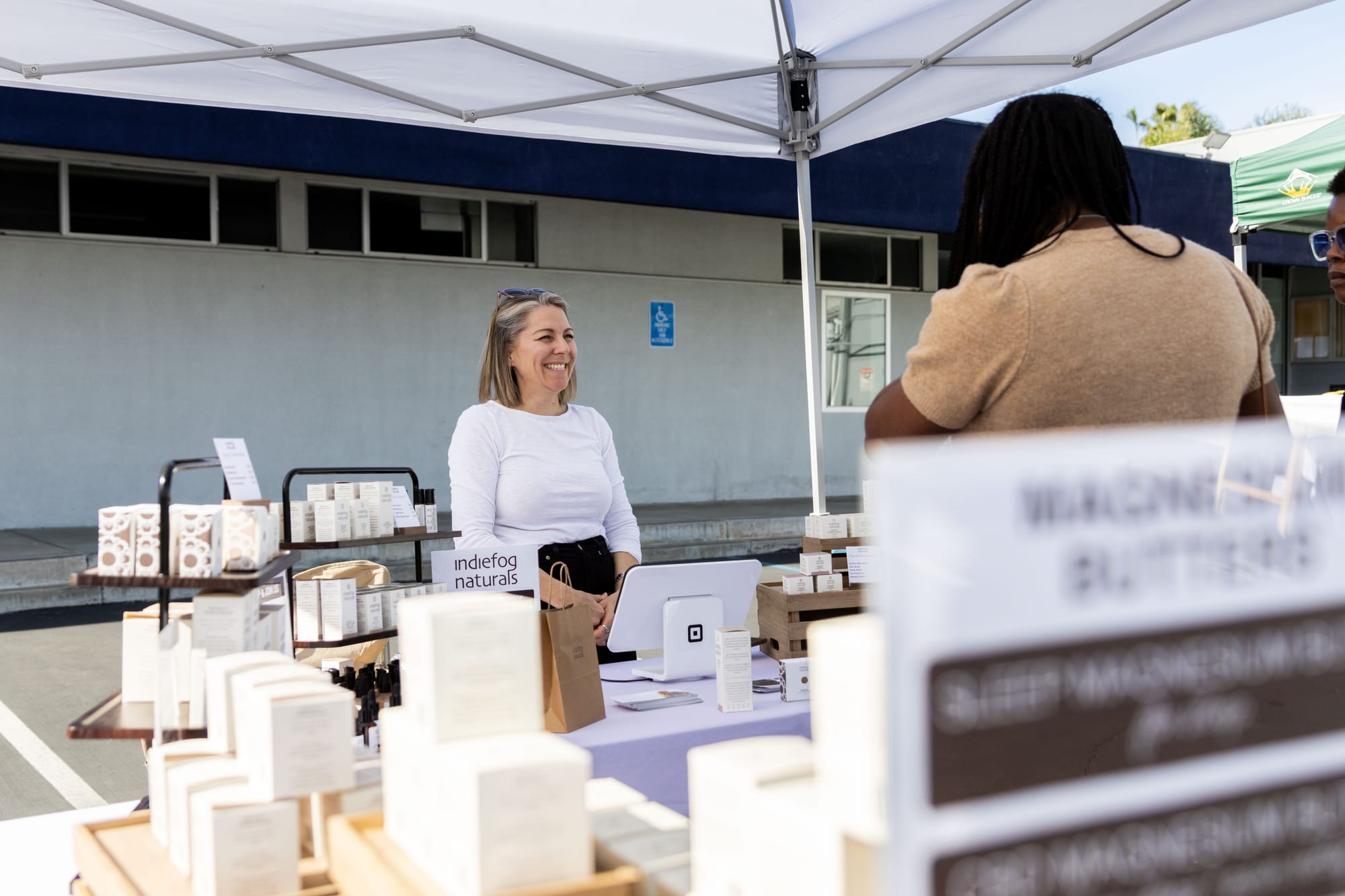 A woman speaks to two other people during an outdoor market