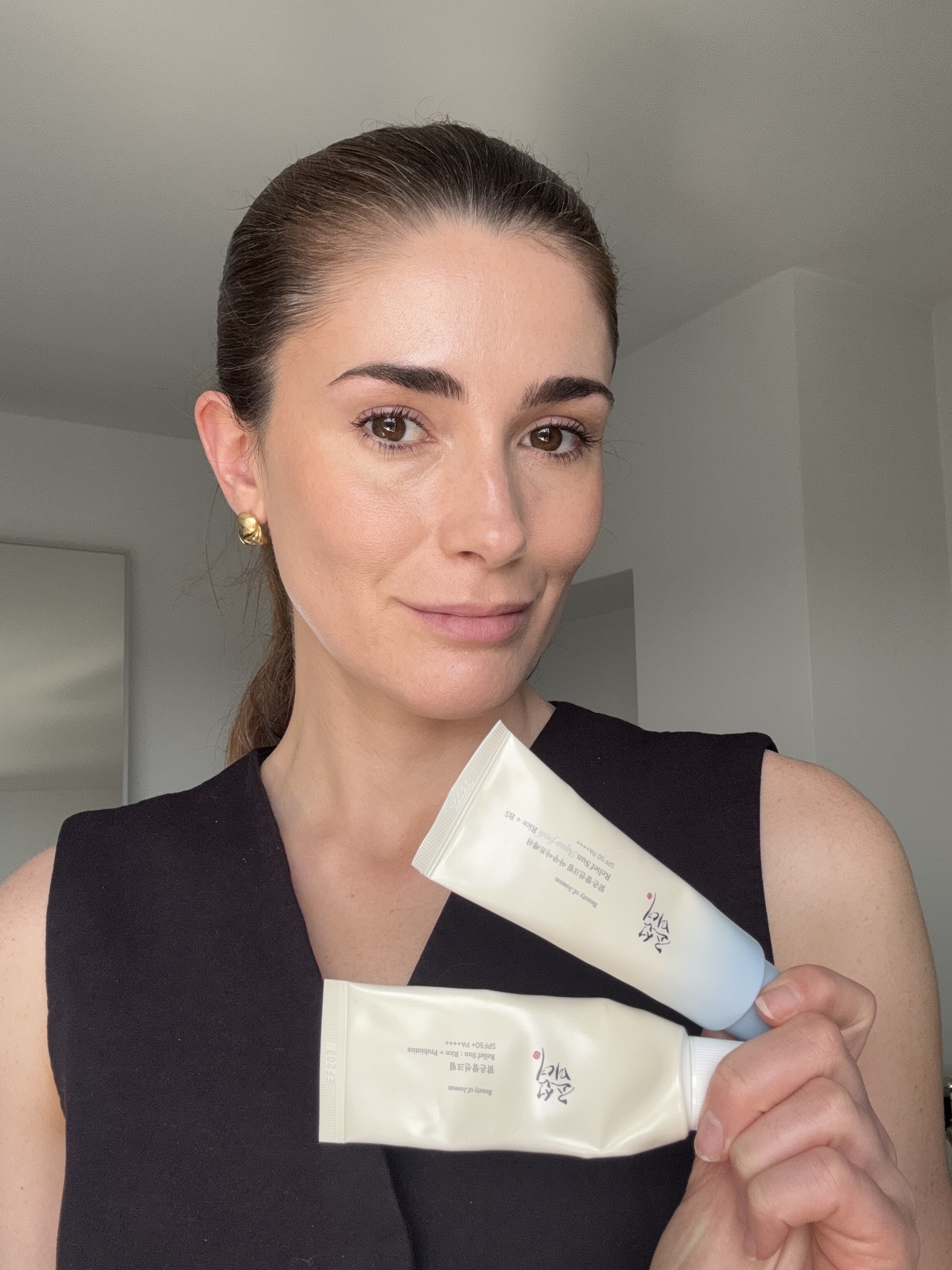 Beauty editor Eleanor Vousden holding two Beauty of Joseon SPFs