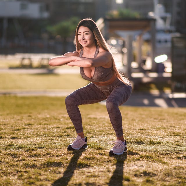 Smiling woman exercising in public park