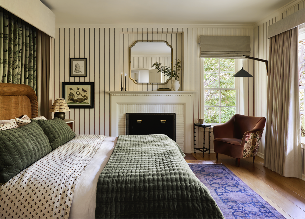 Cozy bedroom interior with a bed, seating area, and artwork.