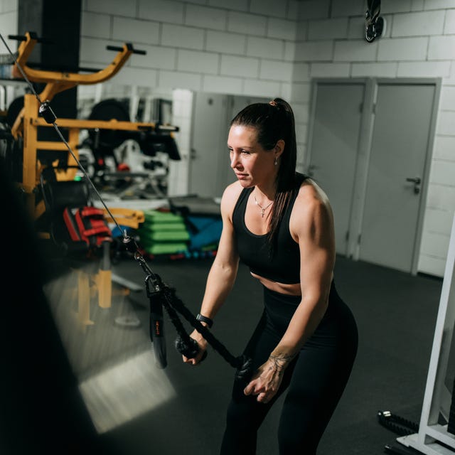 Woman training in gym with cable machine