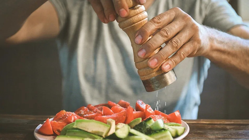 man salts fresh vegetables