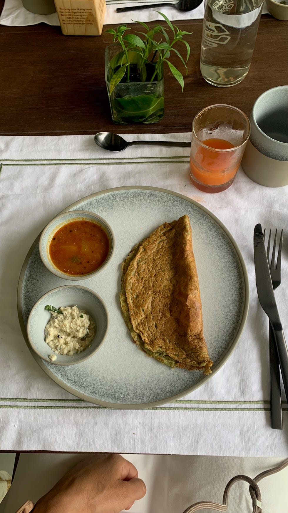 serving of a dish with a side of sauces on a table
