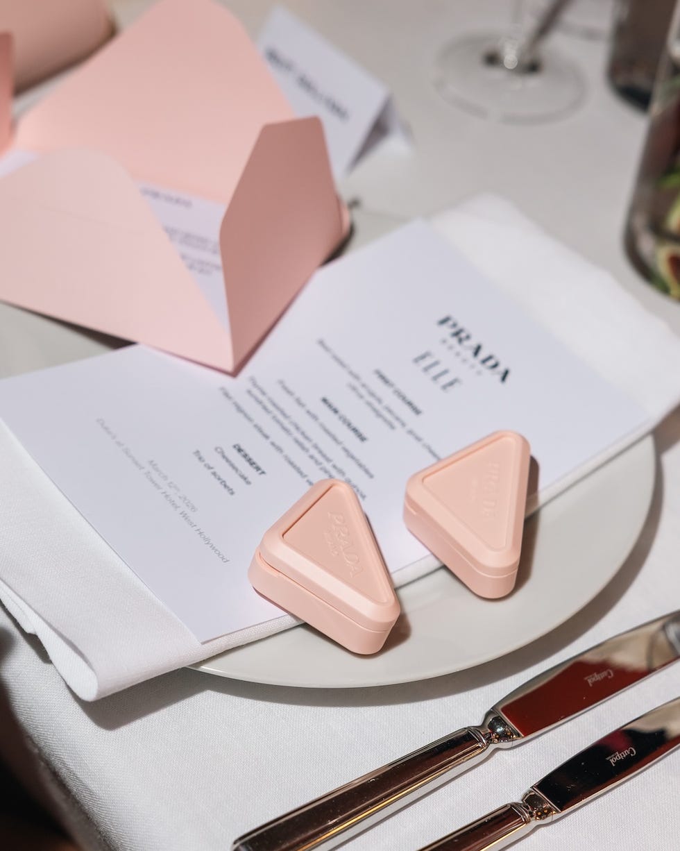 table setting featuring a menu pink triangular containers and silver cutlery
