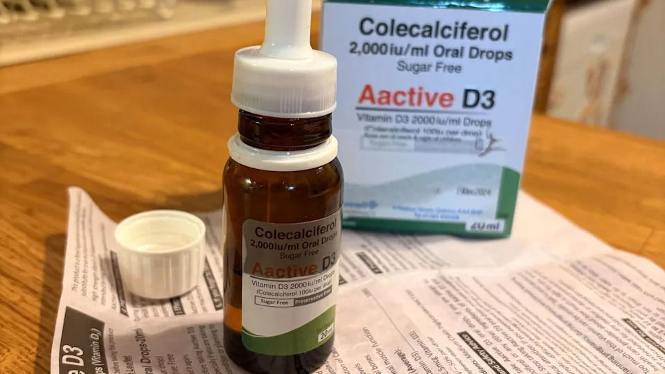 A bottle of vitamin D3 oral drops labelled “Aactive D3”, shown with its packaging and leaflet on a table.