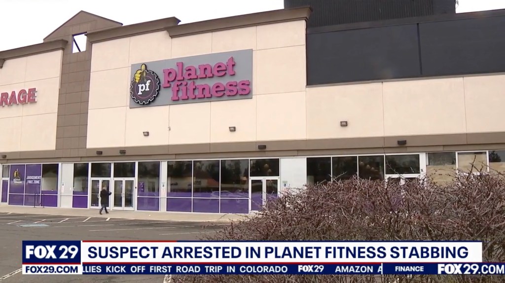 Exterior of a Planet Fitness gym with "JUDGEMENT FREE ZONE" visible on a window.