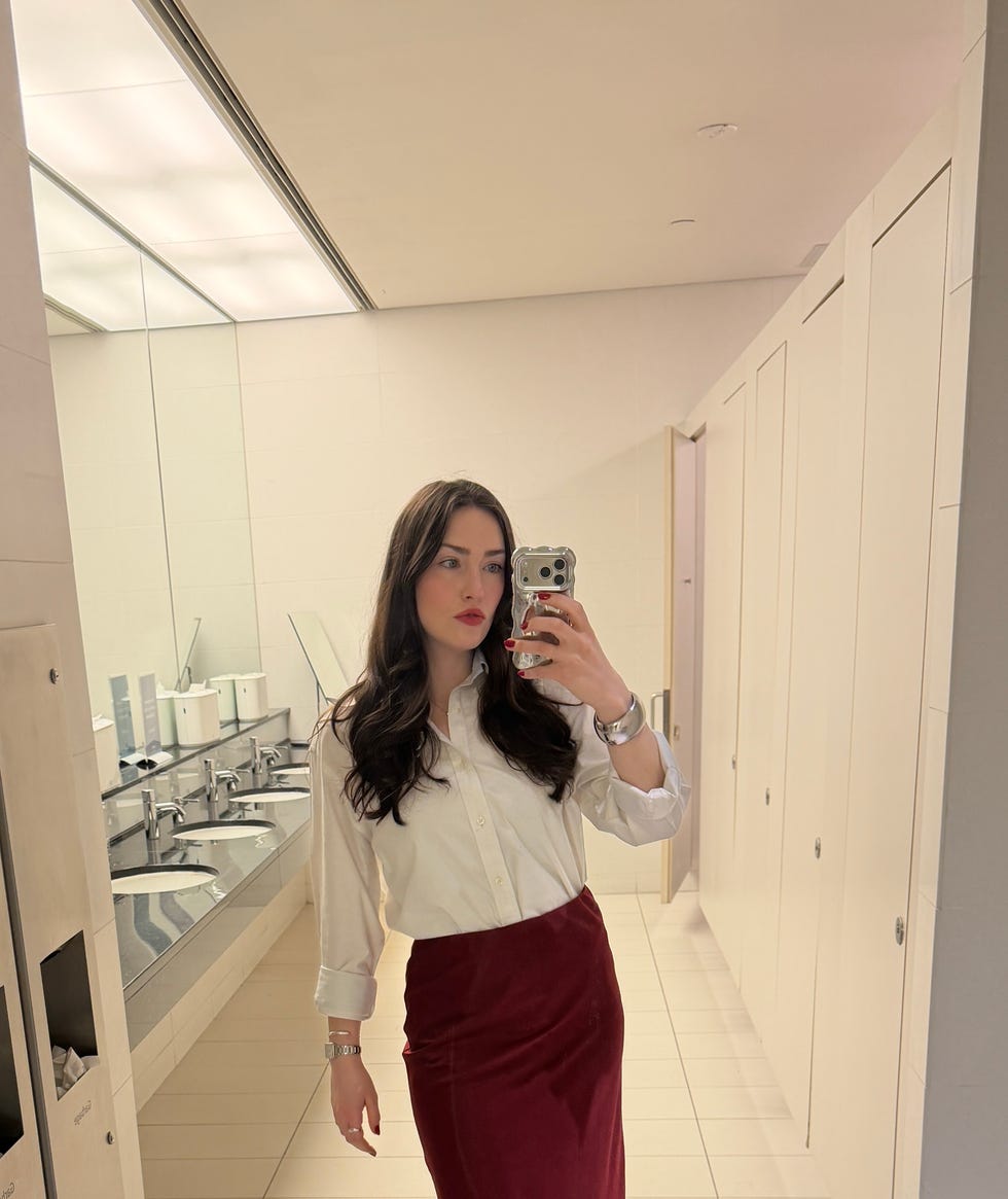 Person taking a mirror selfie in a restroom.